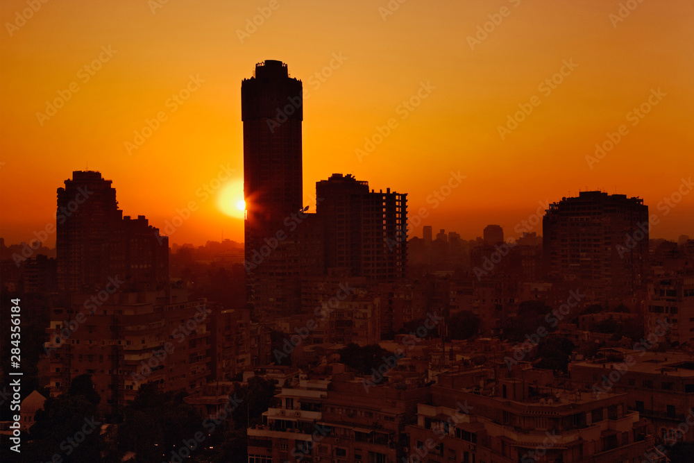 Sunset behind tall apartment building, Cairo, Egypt