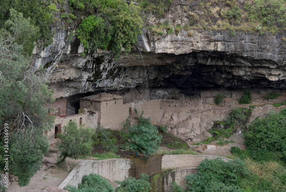 Ethiopia: Lalibela, Blue Nile River Basin, exterior of St. Neakutoleab Monastery, built in a cave below a cliff wall