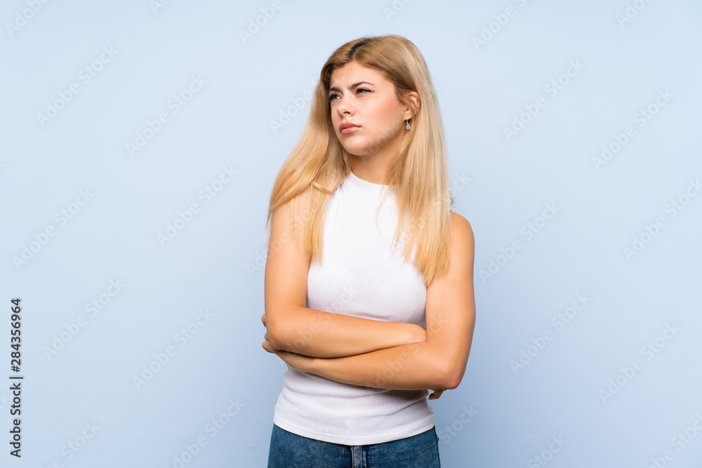 Teenager girl over isolated blue background holding copyspace imaginary on the palm to insert an ad Teenager girl over isolated blue background holding copyspace imaginary on the palm to insert an ad