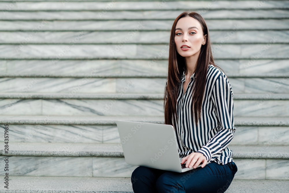 woman doing freelance work on laptop outdoors