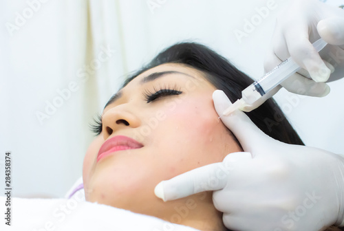 A woman is doing cosmetic injection