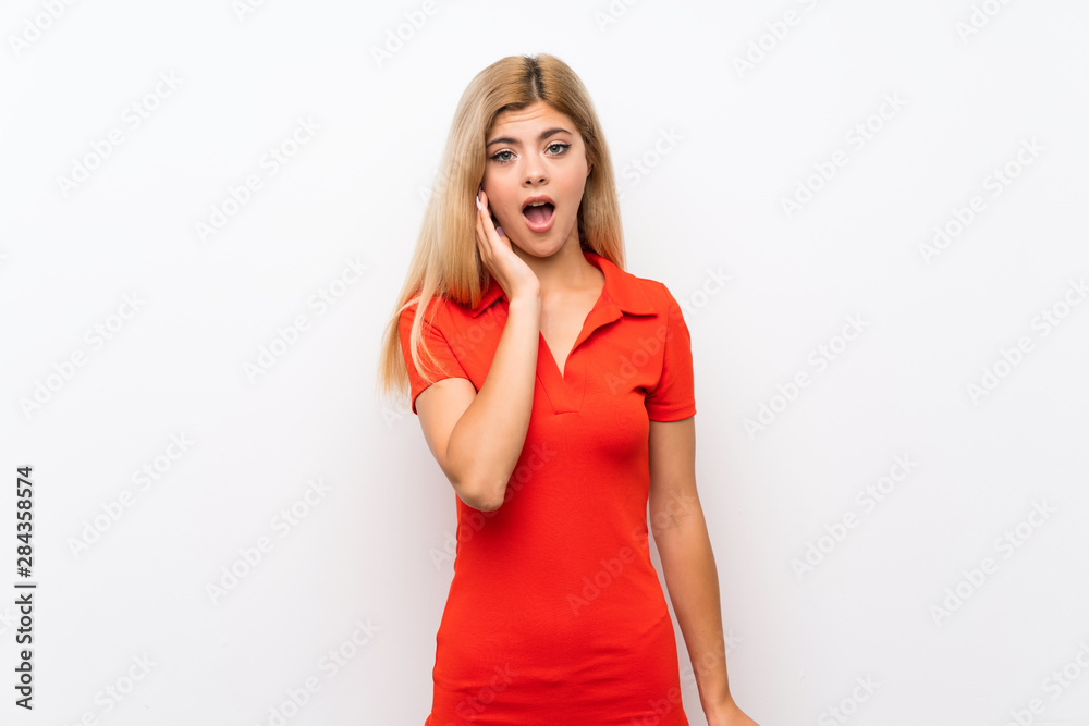 Teenager girl over isolated white background surprised and shocked while looking right Teenager girl over isolated white background surprised and shocked while looking right