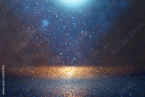 blackground of abstract glitter lights. blue, gold and black. de focused © tomertu