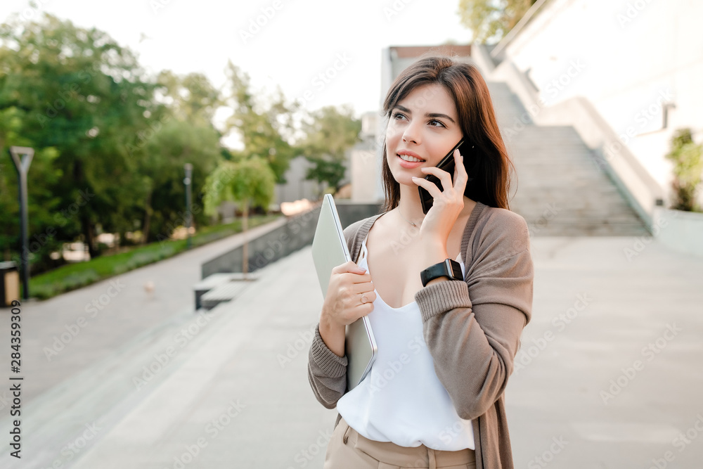 beautiful woman using phone outdoors in the city park beautiful woman using phone outdoors in the city park