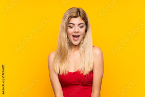 Teenager girl over isolated yellow background with surprise facial expression