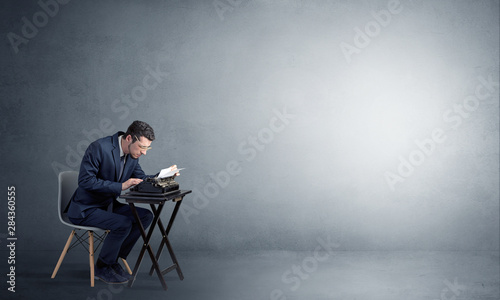 Man working hard on a typewriter in an empty space