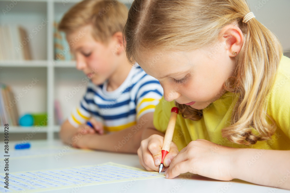 Cute schoolchildren are came back to school and learning at the table in classroom Cute schoolchildren are came back to school and learning at the table in classroom