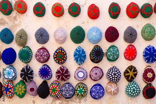 Morocco, Essaouira. Colorful men's hats (tagiya) hanging on wall. photo