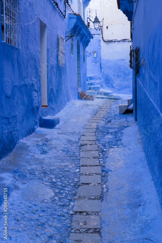 Morocco, Chefchaouen. A quiet alleyway in blue, the typical paint color of the village. © Brenda Tharp/Danita Delimont