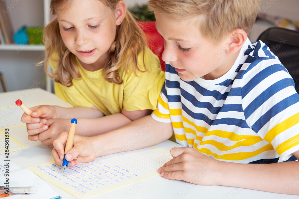 Cute schoolchildren are came back to school and learning at the table in classroom Cute schoolchildren are came back to school and learning at the table in classroom