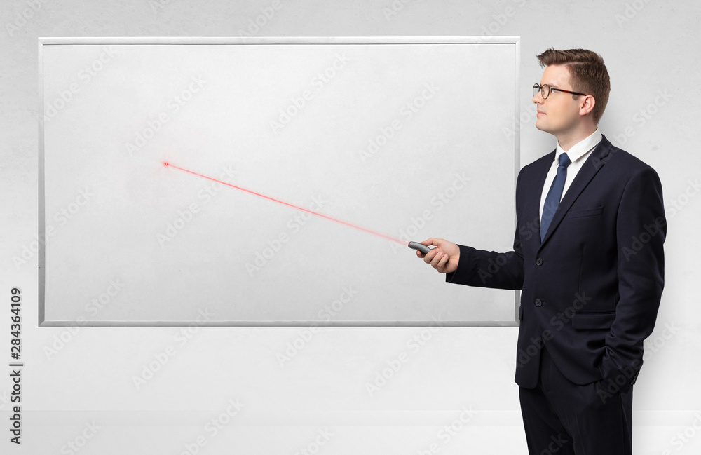 Young businessman with laser pointer and copyspace white blackboard Young businessman with laser pointer and copyspace white blackboard