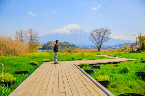 Fuji Mountain and A boy. Mt diamond fuji with snow and flower garden along the lake walkway at Kawaguchiko lake in japan, Mt Fuji is one of famous place in Japan. 