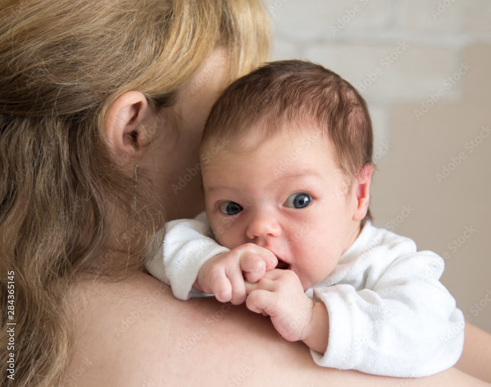 Young woman holds a newborn baby on the shoulder Young woman holds a newborn baby on the shoulder