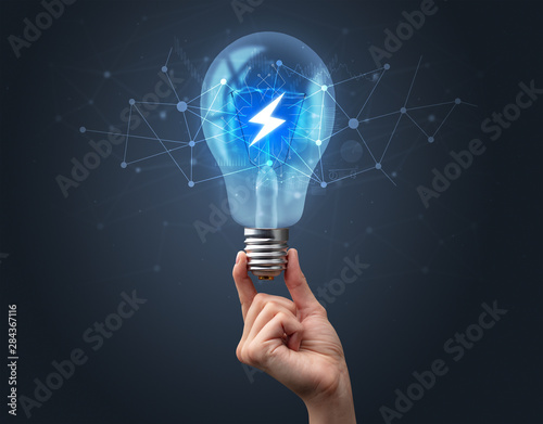 Hand holding light bulb on dark background. Networking idea concept