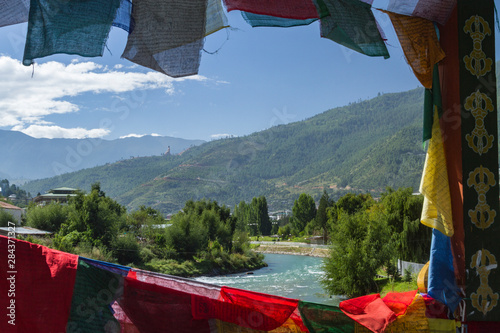 Fototapeta Naklejka Na Ścianę i Meble -  Bhutan, Punakha. Prayer flags line the cantilever bridge over the Mo Chu river at Punakha.