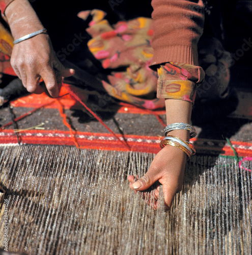 Afghanistan, Shibar Pass. A weaver works on a woolen rug in the Shibar Pass area of Afghanistan. photo