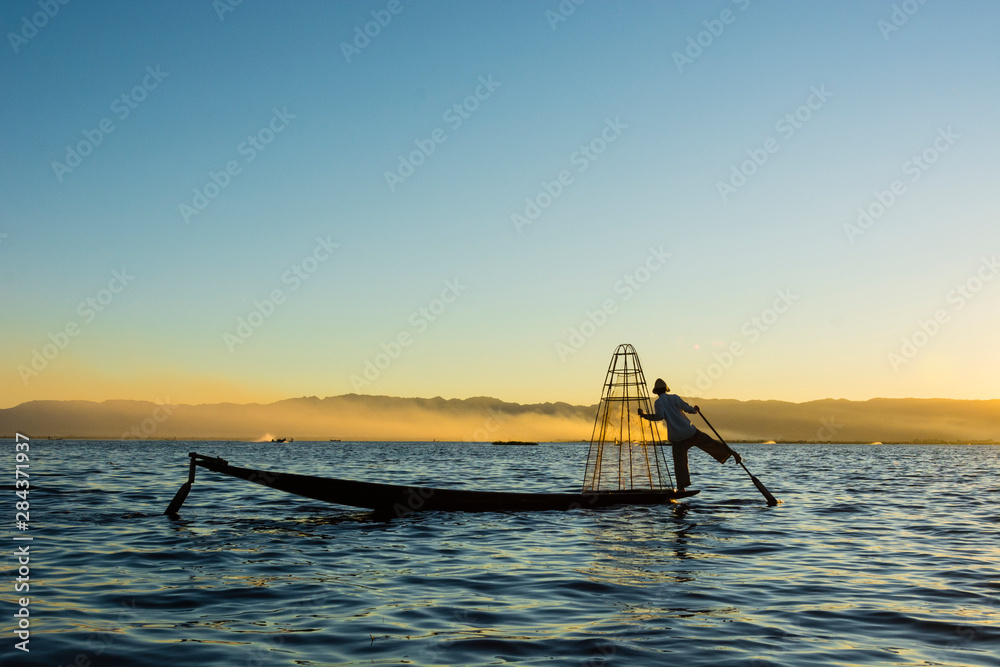 Myanmar. Shan State. Inle Lake. Intha fisherman rowing with his foot.