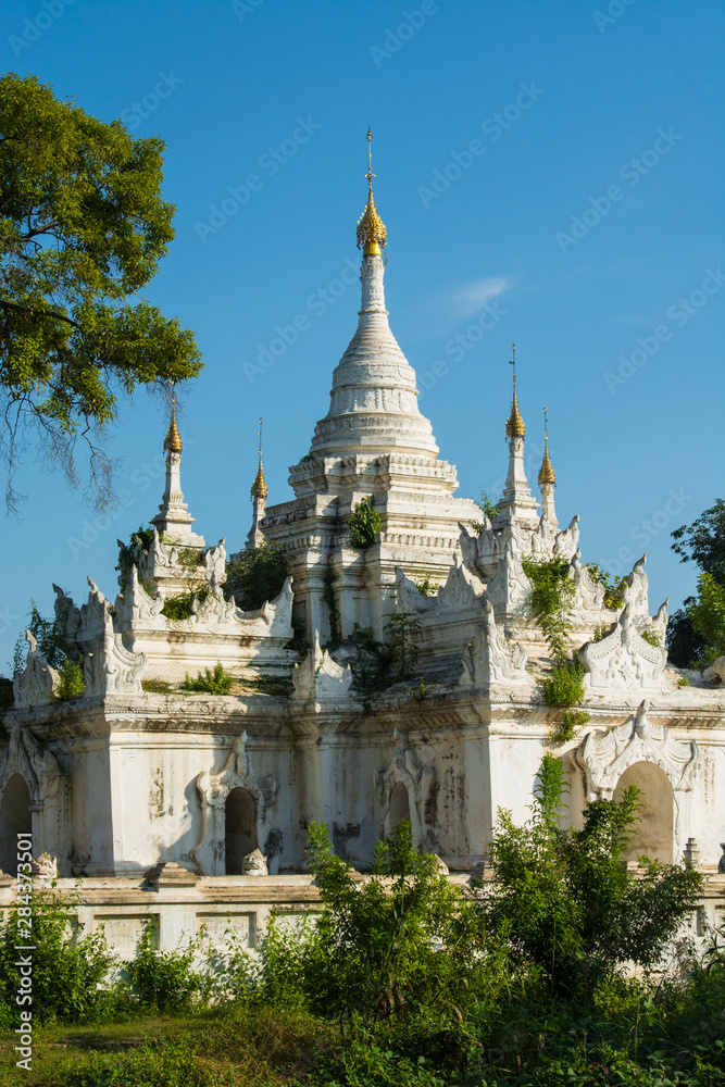 Myanmar. Mandalay. Inwa. White temple surrounded by greenery.