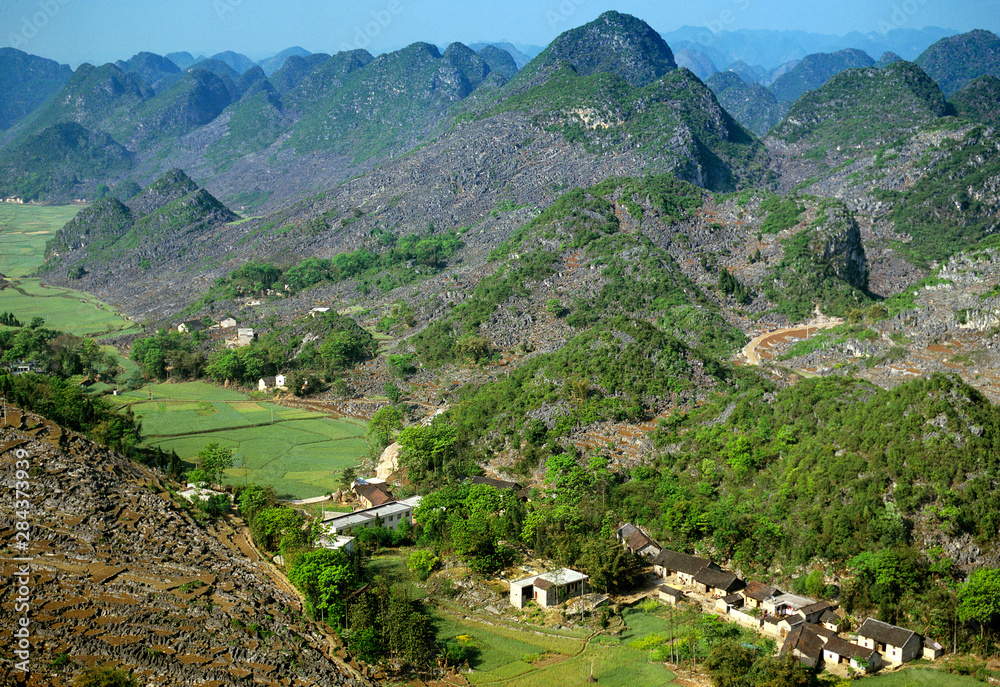 Asia, China, Guizhou Province, Xingyi. Limestone karst mountains surround farm fields.