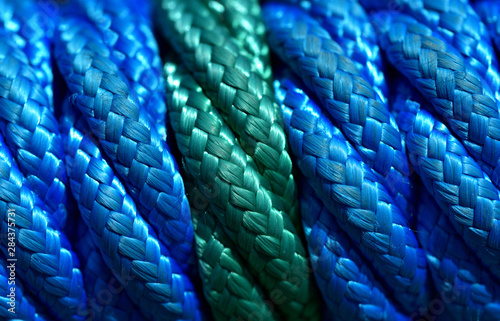 Close-up of a thick green and blue plastic rope with many fibers woven into each other