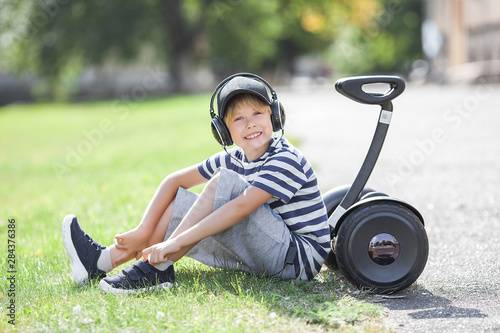 Smiling child riding segway. Active youth. Cute boy outdoors with electric rover. photo