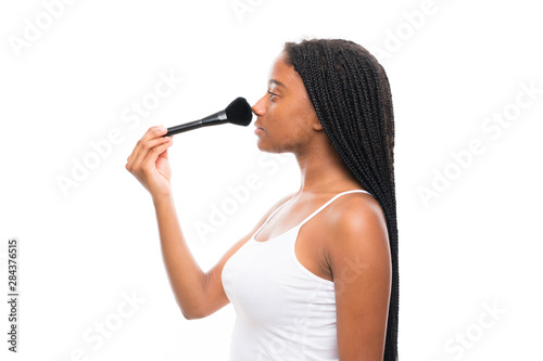 African American teenager girl with long braided hair with makeup brush