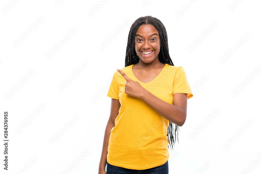 African American teenager girl with long braided hair over isolated white background pointing finger to the side African American teenager girl with long braided hair over isolated white background pointing finger to the side