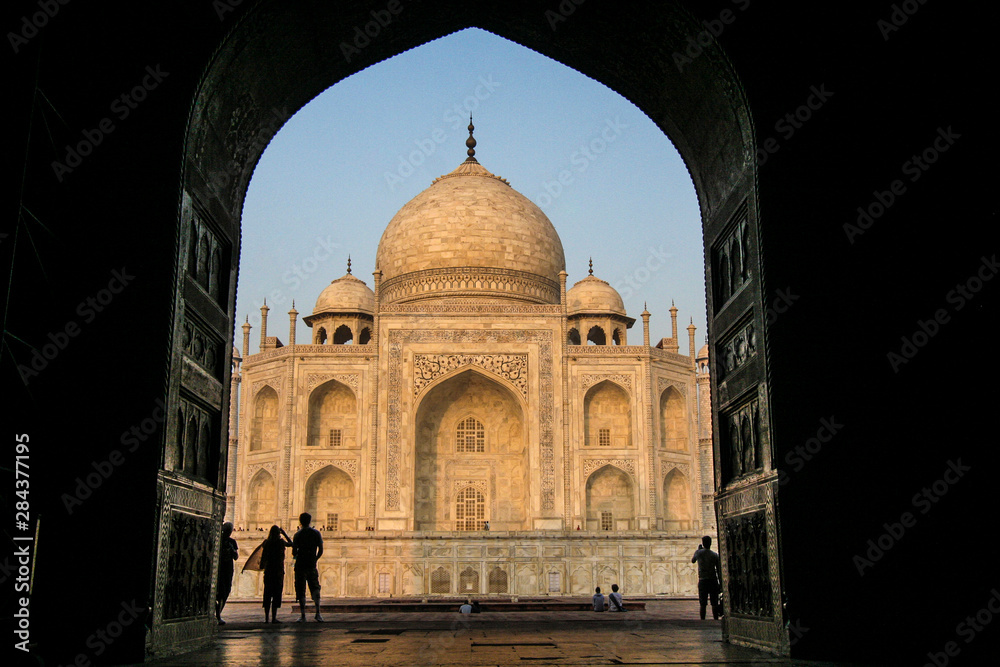 Agra, Delhi, Taj Mahal. Large, open, carved doorway leads to the Taj Mahal, as people look at it