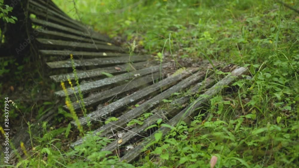Old wooden broken weathered wooden fence fell down and laying on green grass on ground. Real time full hd video footage. Old wooden broken weathered wooden fence fell down and laying on green grass on ground. Real time full hd video footage.