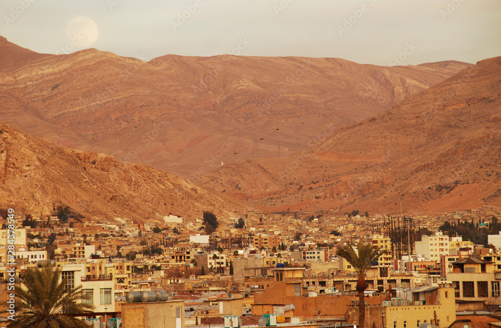 Iran, Shiraz, giant moonrise of dry mountain and city