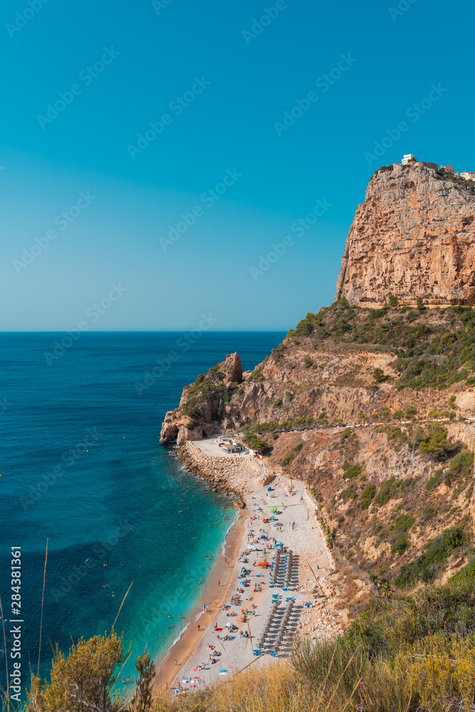 op view of people at colorful and picturesque Beach  lagoon  with turquoise  water in Javea , Alicante, Spain. Costa Blanca.