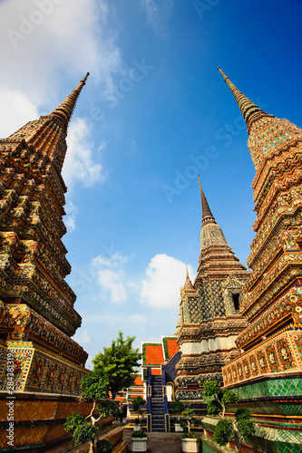 Upward view of chedis including distant Phra Si Sanphet Chedi, Wat Pho, Bangkok, Thailand