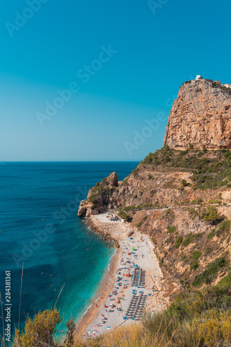 op view of people at colorful and picturesque Beach lagoon with turquoise water in Javea , Alicante, Spain. Costa Blanca.