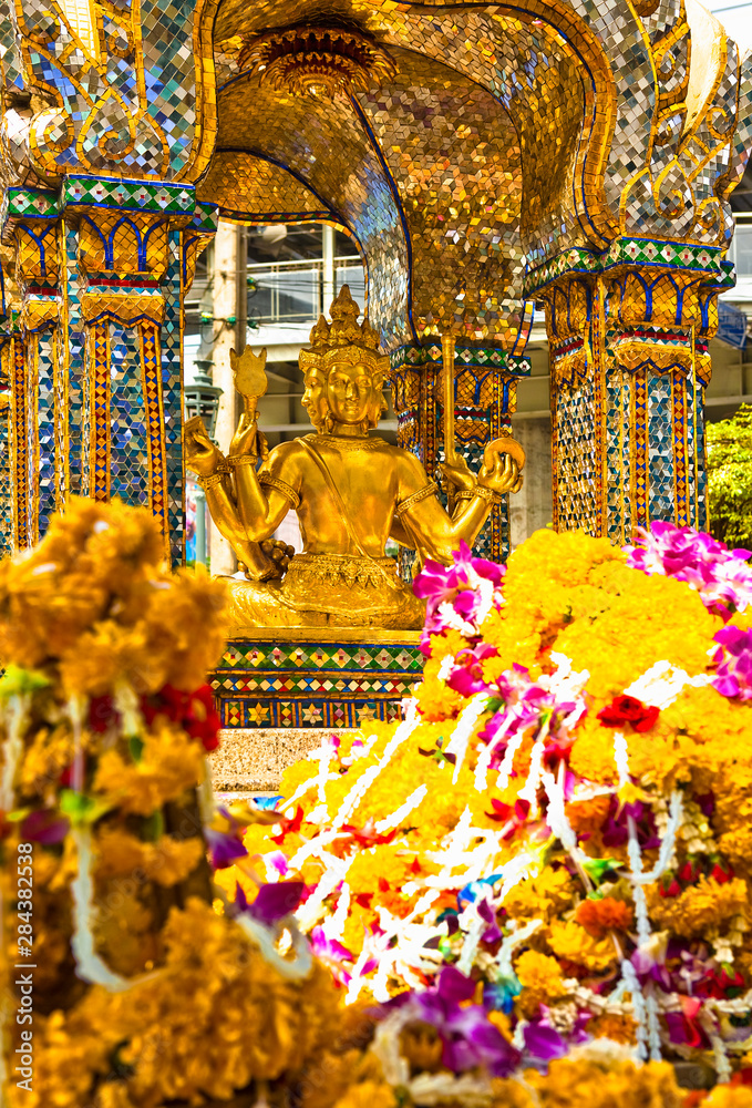 Bangkok, Thailand - Bangkok, Thailand - Offerings of incense, flowers and boxes are left at a Buddhist statue.