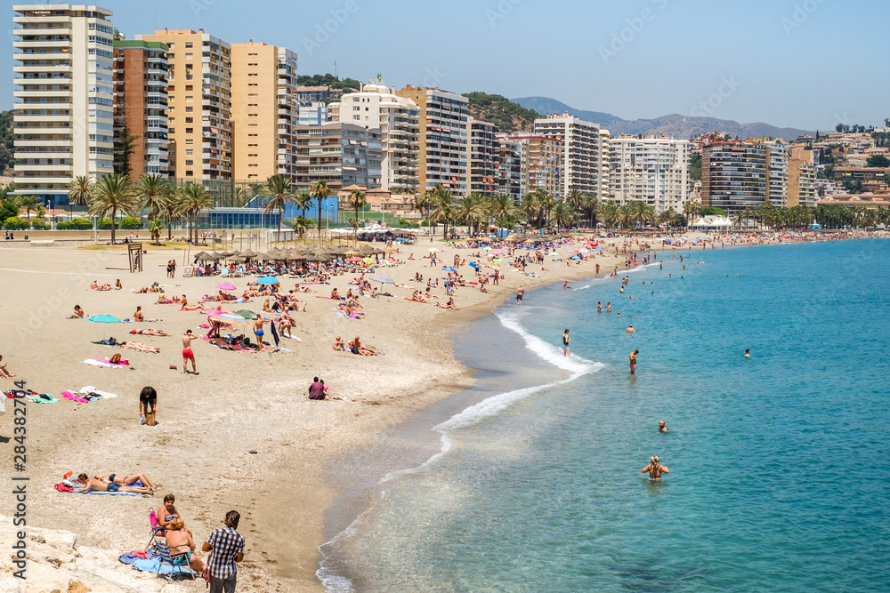 Holidaymakers sunbathing on Malagueta beach
