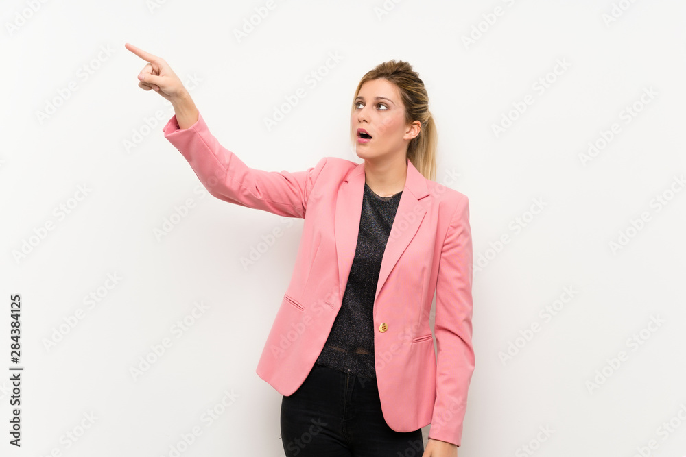 Young blonde woman with pink suit pointing away Young blonde woman with pink suit pointing away