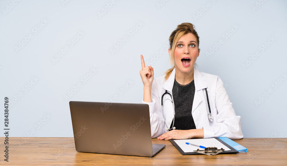 Blonde doctor woman intending to realizes the solution while lifting a finger up Blonde doctor woman intending to realizes the solution while lifting a finger up