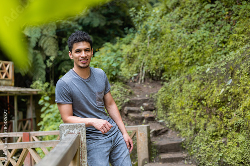 Hispanic traveler lying on a balcony in a natural park surrounded by nature smiling and looking in front - man in Fuentes Georginas Guatemala photo