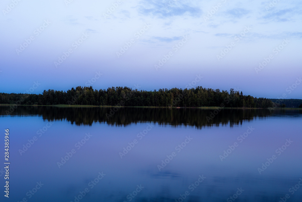 Fototapeta premium Blue hour after the sunset on the shores of the calm Saimaa lake in the Linnansaari National Park in Finland