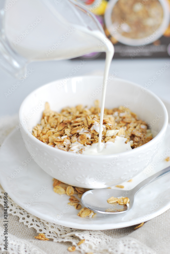 Granola breakfast with milk in a white bowl Granola breakfast with milk in a white bowl
