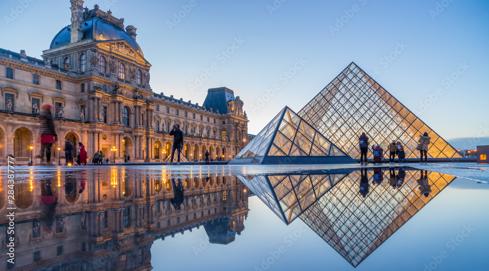 Louvren som speglar sig i vatten