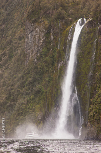 South Pacific  New Zealand  South Island  Fiordland National Park. A tourist boat moves close to Stirling Falls. 