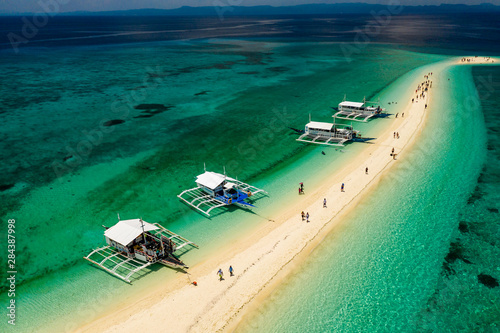 KALANGGAMAN ISLAND, PHILIPPINES - 24TH MAY 2019: SCUBA diving and snorkel boats moored off a sandspit on the tiny tropical island of Kalanggaman in the central Philippines.