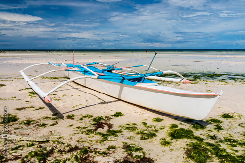 Colorful wooden boats on a large beach at low tide (Anda, Bohol)