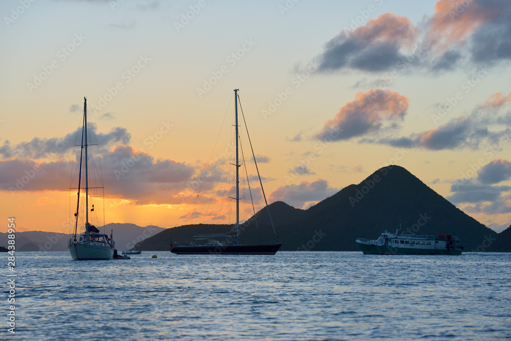 Fototapeta premium British Virgin Islands, Tortola. Caribbean sunset with sailboats and ferry at Soper's Hole, West End