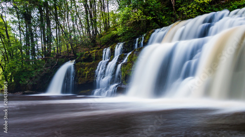 A scenic waterfall surrounded by forest in South Wales  Sgwd y Pannwr  Waterfall country  Wales 