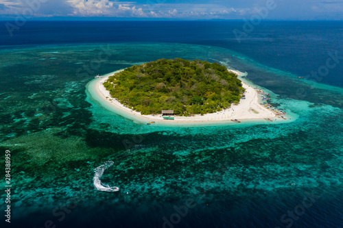 Aerial drone view of a beautiful tropical island and surrounding coral reef