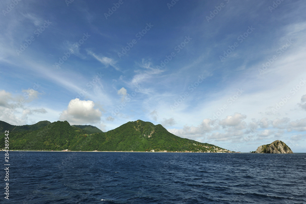 Dominica, Roseau, rock which southern tip of the island and lush green hills in background