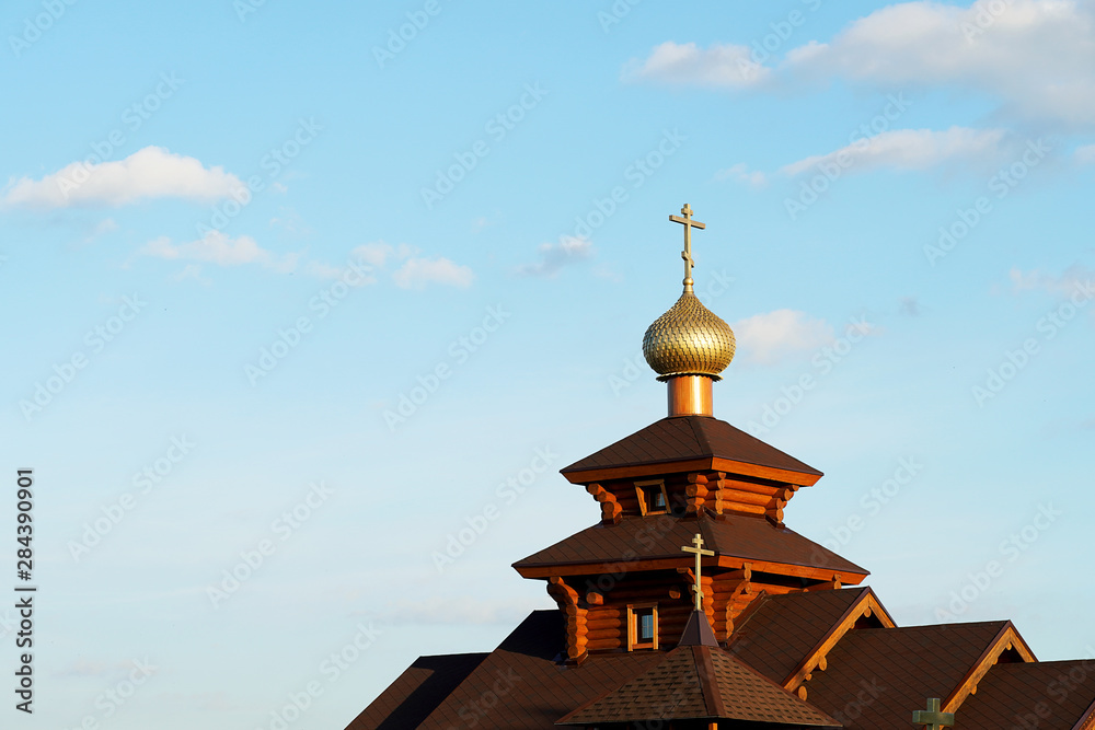 Wooden church with a cross and a golden dome. Brown logs, religion. Wooden church with a cross and a golden dome. Brown logs, religion.