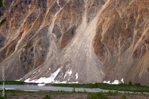 Canada, British Columbia, Alsek River Valley. Alsek River flows next to mountain.  photo